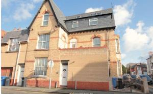 a large brick house with a black roof at Paradise St Apartment Top Floor 3 flights of stairs 3 bed 1 bathroom in Rhyl