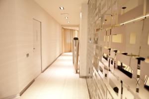un corridoio con pareti bianche e pavimenti piastrellati bianchi di Albergo Dei Laghi a Turate
