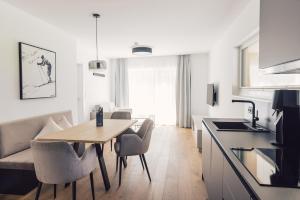 eine Küche und ein Wohnzimmer mit einem Tisch und Stühlen in der Unterkunft Sima-Apartments in Längenfeld