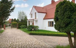 Biały dom z czerwonym dachem i ceglanym podjazdem w obiekcie Villa SEEhochDREI - Ferienhaus w mieście Dobiesławiec