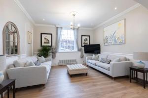 Beautiful 4 Bedroom Home في تشلتنهام: غرفة معيشة مع كنبتين وتلفزيون