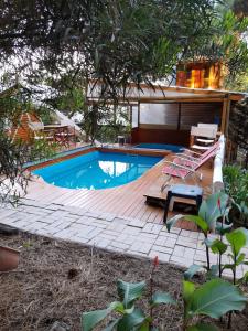 una piscina con terraza y una casa en Cabanas Las Escondidas en Monte Hermoso