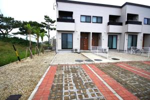 a house with a brick walkway in front of it at Plage Garden Place　A-101 in Miyako Island