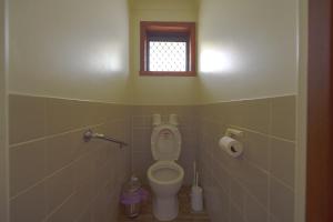 La salle de bains est pourvue de toilettes et d'une fenêtre. dans l'établissement DingDing upst-airs yellow House Free parking, à Sandy Bay