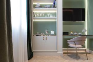 a kitchen with a white cabinet and a chair at Hotel La Gemma in Florence