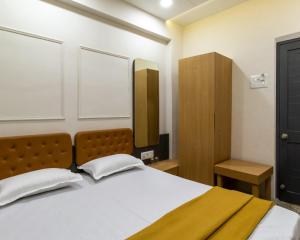 1 dormitorio con 1 cama grande y armario de madera en PRINCE RESIDENCY CLUB HOUSE, en Jamnagar