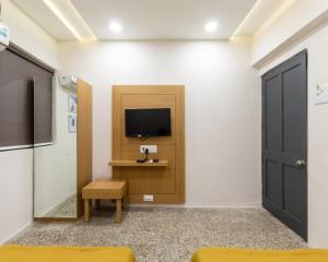 Habitación con puerta y TV en la pared en PRINCE RESIDENCY CLUB HOUSE, en Jamnagar