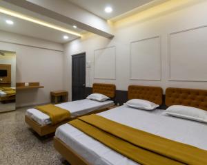 a room with two beds in a room at PRINCE RESIDENCY CLUB HOUSE in Jamnagar