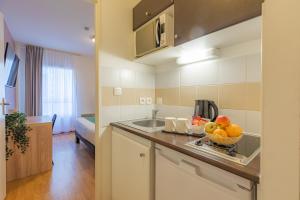 a kitchen with a bowl of fruit on a counter at Appart’City Confort Nantes Centre in Nantes