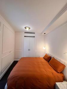 um quarto com uma cama grande com lençóis laranja em Elegante appartamento in zona Tortona-Solari em Milão