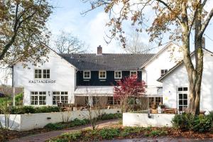 a house with a black and white facade at Boetiekhotel De Kastanjehof in Lage-Vuursche