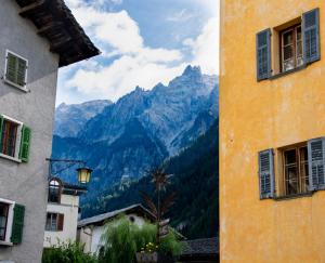 a view of a mountain from between two buildings at Hotel Corona in Vicosoprano