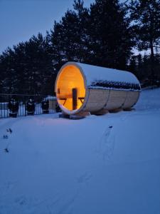 ein rundes Gebäude mit einem Licht im Schnee in der Unterkunft Mergen Bike & Ski Resort in Burg Niedzica