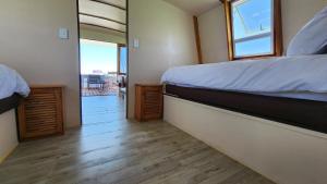 a small bedroom with a bed and a balcony at Kraalbaai Lifestyle House Boats in Langebaan
