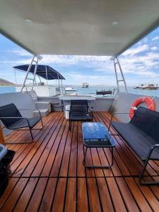a deck of a boat with chairs and a table at Kraalbaai Lifestyle House Boats in Langebaan