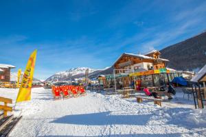 une station de ski avec des chaises et un bâtiment dans la neige dans l'établissement Marlies Ski in - Ski out Mt 50 - Happy Rentals, à Livigno