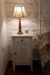 une lampe sur une table de nuit blanche à côté d'un lit dans l'établissement Bianka Apartment, à Zagreb