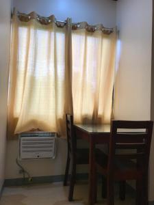una mesa y sillas frente a una ventana en Drew Hostel en Tagbilaran City