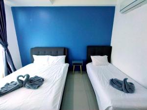 two beds in a room with blue walls at 191 Cozy Casa Kayangan 3BR 6pax by Grab A Stay in Ipoh