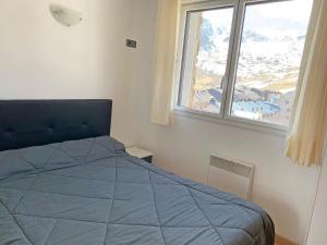 a bedroom with a blue bed and a window at Apartamentos Araco 3000 in Pas de la Casa