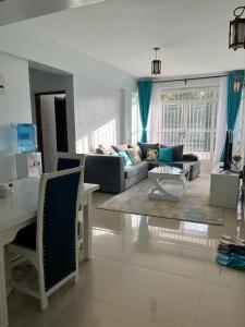ein Wohnzimmer mit einem Sofa und einem Tisch in der Unterkunft Zoe Homes Greypoint 1br and 2bedroom Apartment 301 in Kericho