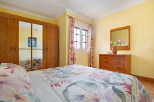 Un dormitorio con una cama, una cómoda y un espejo. en Casa Paco 2, en Costa Calma 17 fotos más