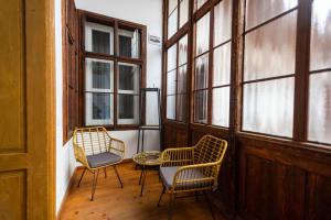 Duas cadeiras e uma mesa num quarto com janelas em Althof Apartments em Sibiu