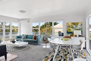 una sala de estar con un sofá y una mesa en Emily's Beach House - Kaiteriteri Holiday Home, en Kaiteriteri
