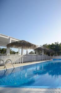 een groot blauw zwembad met stoelen en parasols bij Aspro Phos Santorini Hotel in Perissa