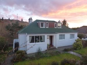 Casa blanca con techo verde en Don Muir Guesthouse, en Oban