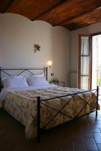 Il Poggiolo في Montieri: غرفة نوم بسرير كبير ومخدات بيضاء