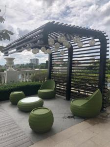 a pergola with green seating on a patio at Lafayette Park Square Condominium Megaworld in Iloilo City