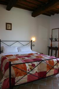 a bedroom with a bed with a colorful comforter at Il Poggiolo in Montieri