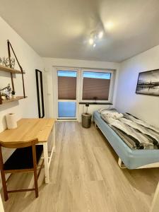 奧胡斯的住宿－City Aarhus，一间卧室配有一张床、一张书桌和两个窗户。