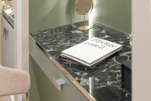 a desk with a book and a mirror on it at Hotel La Gemma in Florence
