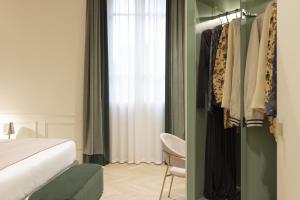 a bedroom with a bed and a closet with clothes at Hotel La Gemma in Florence
