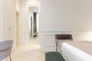 a bedroom with a bed and a chair and a mirror at Hotel La Gemma in Florence