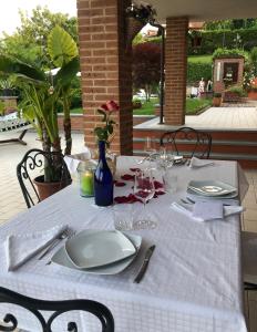 a table with a white table cloth and a white plate at B&B Castelvecchio in Ferrere