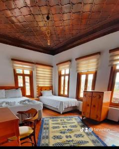 um quarto com 2 camas, uma mesa e janelas em Tarihi Taşkıran Otel em Beypazarı