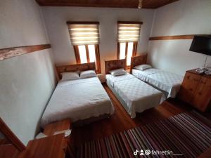 um quarto com duas camas e duas janelas em Tarihi Taşkıran Otel em Beypazarı