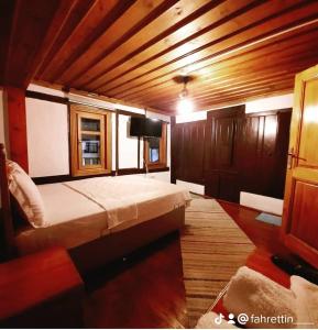 um quarto com uma cama grande e uma televisão em Tarihi Taşkıran Otel em Beypazarı