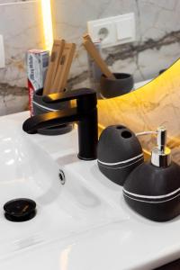 a bathroom sink with a black faucet on it at RentWill apartments Grey in Chişinău