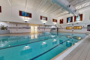 a large indoor swimming pool with blue water at Village Hotel Manchester Bury in Bury
