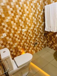 a bathroom with a toilet and a tiled wall at Kigali viewStay in Kigali