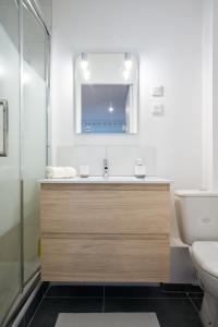 uma casa de banho com um lavatório, um WC e um espelho. em THEM'APPART CHARTRONS em Bordeaux