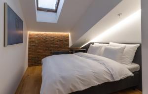 ein Schlafzimmer mit einem weißen Bett und einer Backsteinwand in der Unterkunft Dunten Hotel in Tallinn
