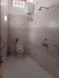 y baño blanco con aseo y ducha. en Kedar View Homestay en Ukhimath