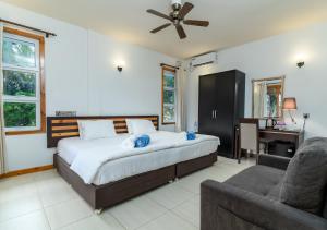 a bedroom with a bed and a couch and a desk at Ukulhas View in Ukulhas