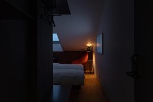 Dunten Hotel في تالين: غرفة مظلمة مع سريرين وضوء على الحائط