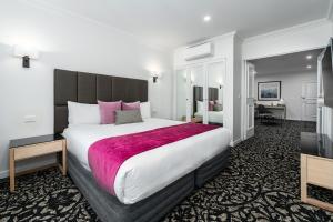 a hotel room with a large bed and a desk at Quality Hotel Parklake Shepparton in Shepparton